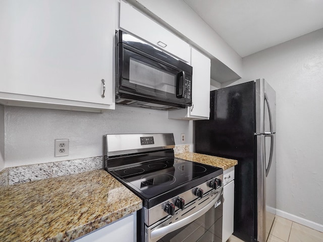 6633 W Airport Blvd Unit 1106, Houston, TX 77035 - kitchen with appliances with stainless steel finishes, white cabinets, light tile patterned floors, baseboards, and light stone counters