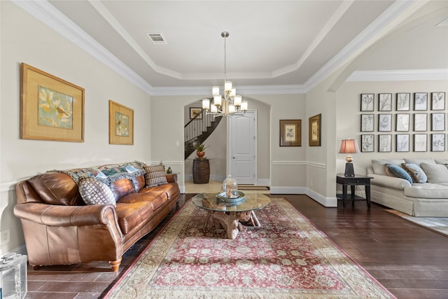 2410 Legends Way, Katy, TX 77493 - living room featuring arched walkways, a raised ceiling, a chandelier, stairway, and dark wood finished floors