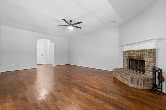 27017 Del Rio Trl W, Magnolia, TX 77355 - unfurnished living room with a ceiling fan, arched walkways, wood finished floors, and a fireplace