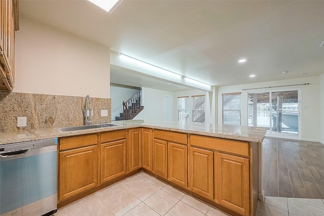 1407 Tiki Dr, Tiki Island, TX 77554 - kitchen featuring dishwasher, a sink, a peninsula, tasteful backsplash, and light stone countertops