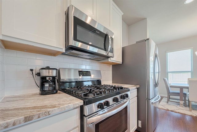 3813 Kirby Ct, Texas City, TX 77591 - kitchen with appliances with stainless steel finishes, light countertops, white cabinets, dark wood-type flooring, and decorative backsplash