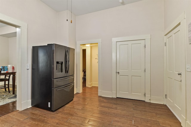 1809 31st St, Galveston, TX 77550 - kitchen with stainless steel fridge, wood finished floors, a high ceiling, and baseboards
