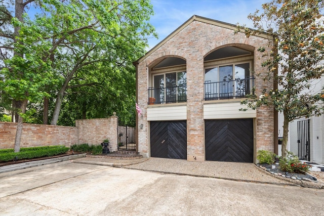 4 River Hollow Ln, Houston, TX 77027 - view of front of property with an attached garage, driveway, a balcony, a gate, and brick siding