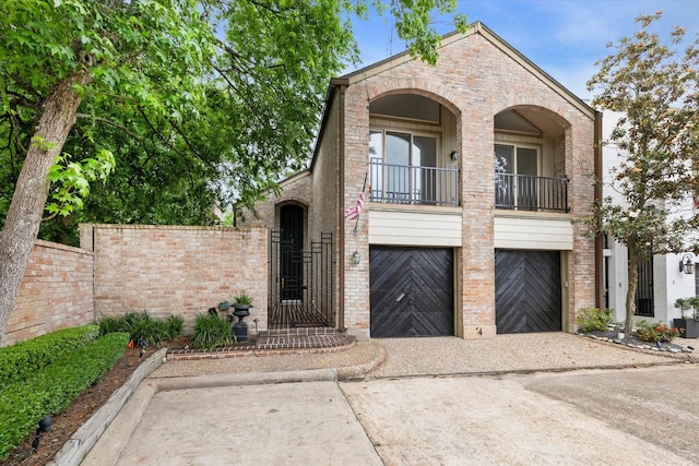 4 River Hollow Ln, Houston, TX 77027 - view of front of property with a balcony, brick siding, concrete driveway, and an attached garage