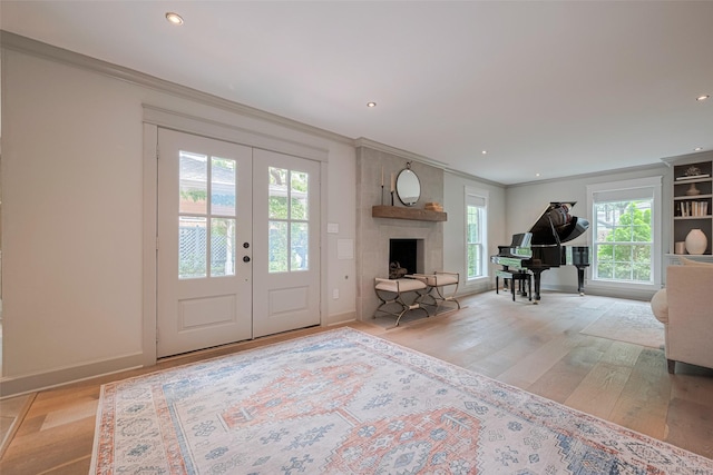 14827 River Forest Dr, Houston, TX 77079 - entryway featuring light wood-style flooring, crown molding, french doors, a fireplace with raised hearth, and recessed lighting