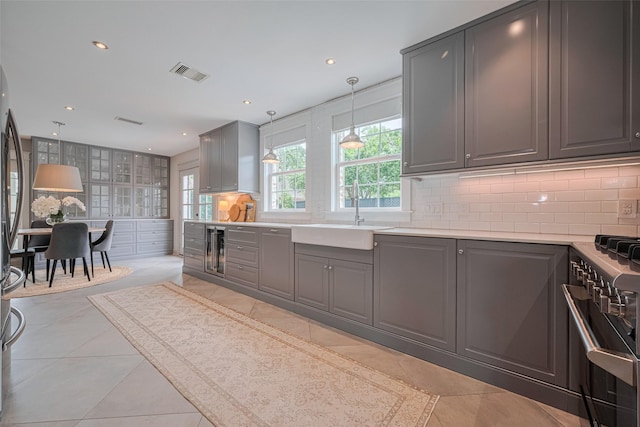 14827 River Forest Dr, Houston, TX 77079 - kitchen with a sink, gray cabinetry, stainless steel stove, beverage cooler, and tasteful backsplash