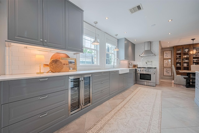 14827 River Forest Dr, Houston, TX 77079 - kitchen with wine cooler, gray cabinets, a sink, high end stainless steel range oven, and wall chimney exhaust hood