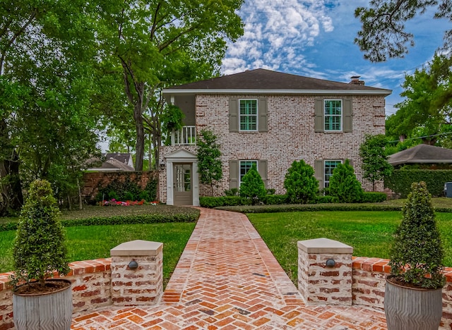 14827 River Forest Dr, Houston, TX 77079 - view of front facade featuring a front yard, a chimney, and brick siding