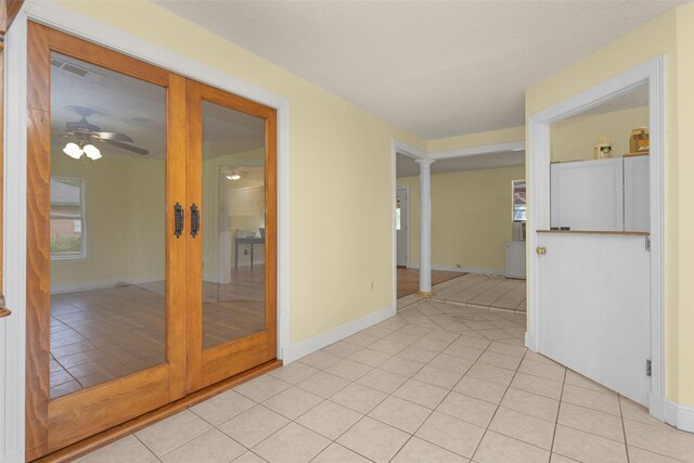 511 Northwood Dr, Conroe, TX 77303 - empty room featuring decorative columns, light tile patterned floors, a ceiling fan, and baseboards