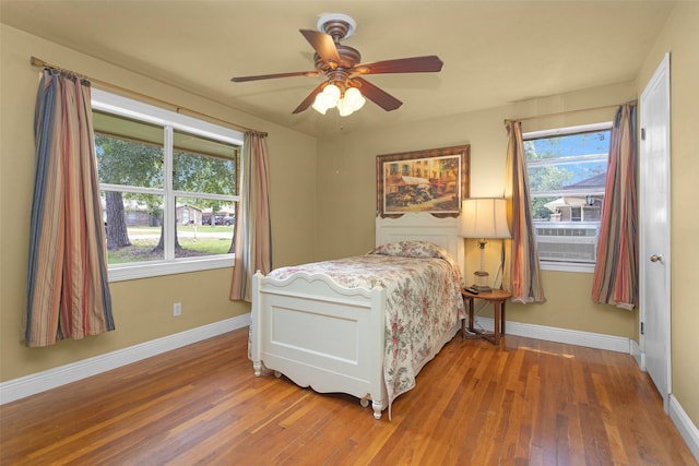511 Northwood Dr, Conroe, TX 77303 - bedroom with wood finished floors, baseboards, and a ceiling fan