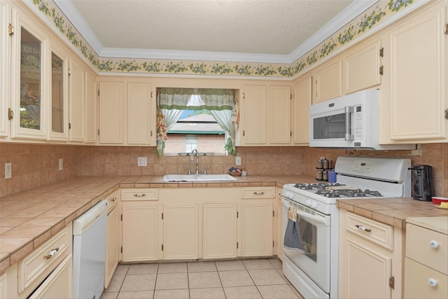 511 Northwood Dr, Conroe, TX 77303 - kitchen featuring white appliances, a sink, tile countertops, cream cabinetry, and crown molding