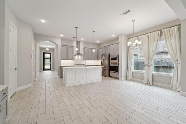 103 Catesby Ct, Conroe, TX 77304 - kitchen with gray cabinets, wall chimney range hood, baseboards, appliances with stainless steel finishes, and light countertops