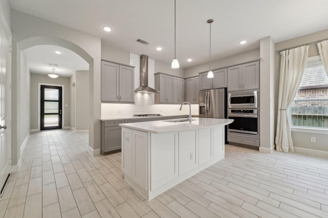 103 Catesby Ct, Conroe, TX 77304 - kitchen with wall chimney range hood, gray cabinetry, stainless steel appliances, a sink, and recessed lighting
