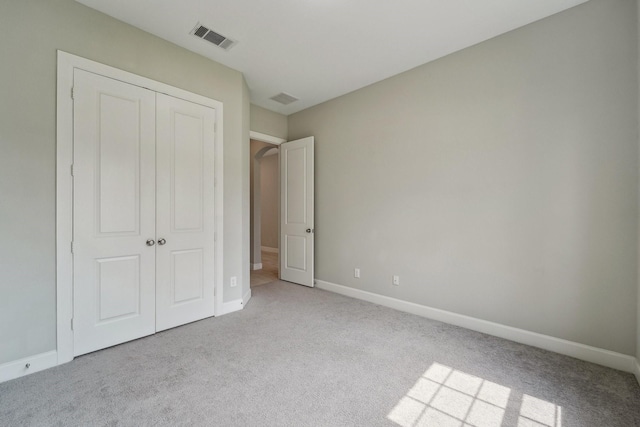 103 Catesby Ct, Conroe, TX 77304 - unfurnished bedroom featuring carpet flooring, a closet, baseboards, and arched walkways