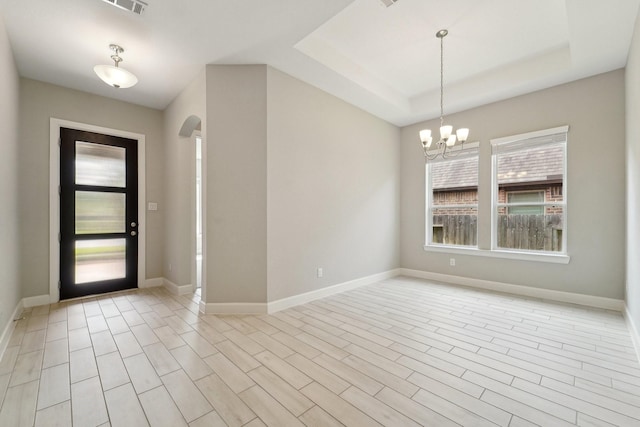 103 Catesby Ct, Conroe, TX 77304 - foyer entrance featuring arched walkways, a chandelier, baseboards, and a tray ceiling