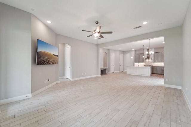 103 Catesby Ct, Conroe, TX 77304 - unfurnished living room with arched walkways, a ceiling fan, baseboards, recessed lighting, and light wood-style floors