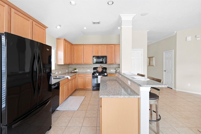 2918 Bright Sky Ct, Spring, TX 77386 - kitchen featuring black appliances, a kitchen breakfast bar, light tile patterned flooring, decorative backsplash, and vaulted ceiling