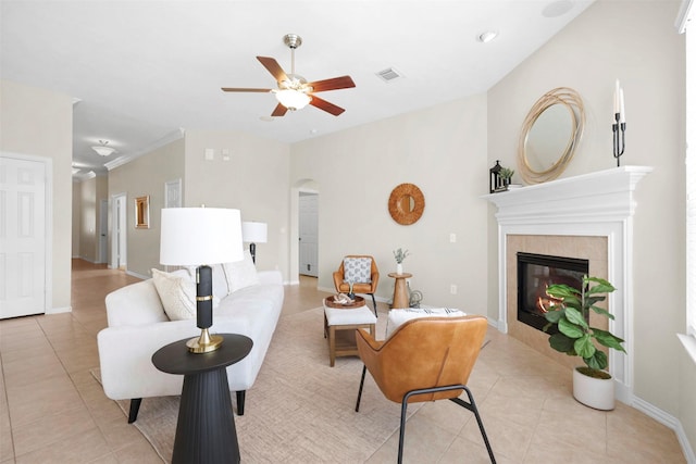 2918 Bright Sky Ct, Spring, TX 77386 - living area with light tile patterned flooring, a tiled fireplace, a ceiling fan, arched walkways, and baseboards