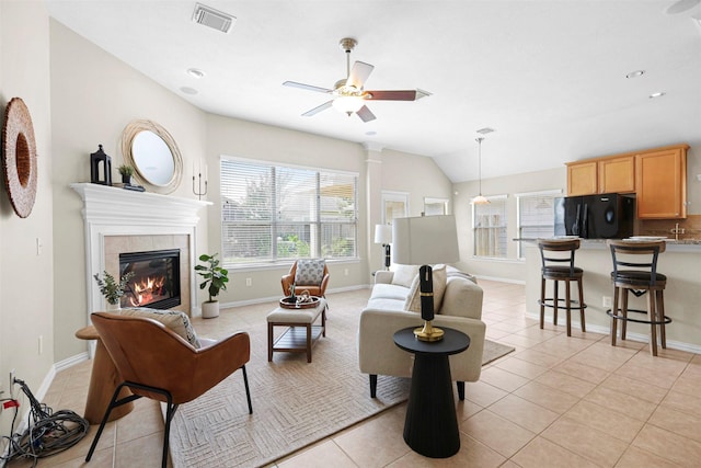 2918 Bright Sky Ct, Spring, TX 77386 - living area featuring light tile patterned floors, a ceiling fan, a fireplace, vaulted ceiling, and baseboards