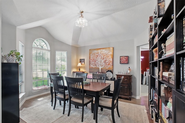 30915 Caraquet Ct, Spring, TX 77386 - dining space with light wood-style flooring, lofted ceiling, baseboards, and a chandelier