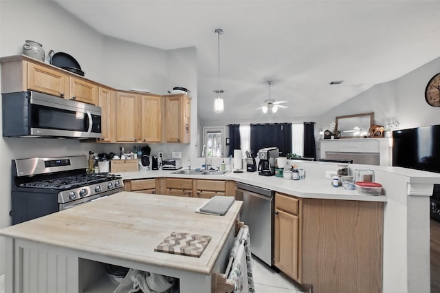 30915 Caraquet Ct, Spring, TX 77386 - kitchen featuring appliances with stainless steel finishes, a sink, a peninsula, light brown cabinets, and vaulted ceiling