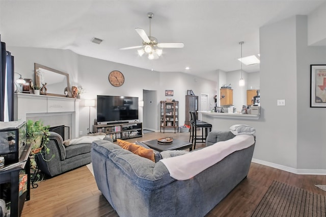 30915 Caraquet Ct, Spring, TX 77386 - living room featuring ceiling fan, wood finished floors, baseboards, and a fireplace