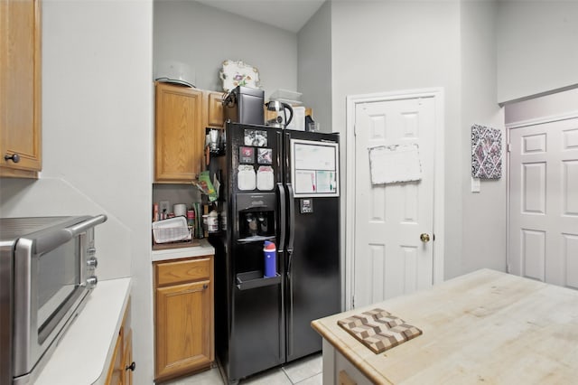 30915 Caraquet Ct, Spring, TX 77386 - kitchen with black fridge, light countertops, and light tile patterned floors
