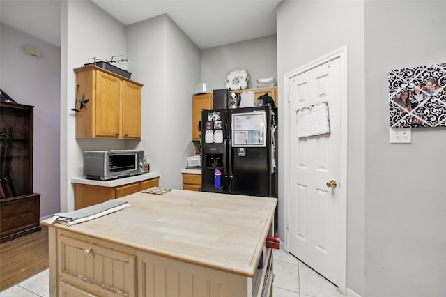 30915 Caraquet Ct, Spring, TX 77386 - kitchen with light tile patterned floors, light countertops, and black refrigerator with ice dispenser