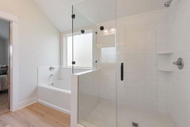 263 Brazos Bnd, Snook, TX 77879 - full bath featuring a bath, wood finished floors, a shower stall, lofted ceiling, and baseboards
