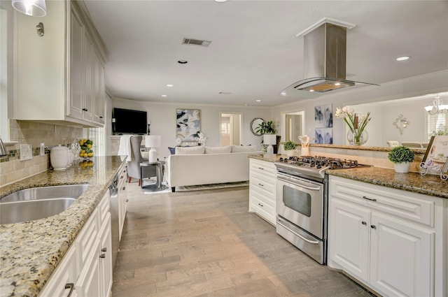 4414 Arnell Dr, Houston, TX 77018 - kitchen featuring stainless steel range with gas stovetop, island range hood, light wood-style flooring, a sink, and crown molding