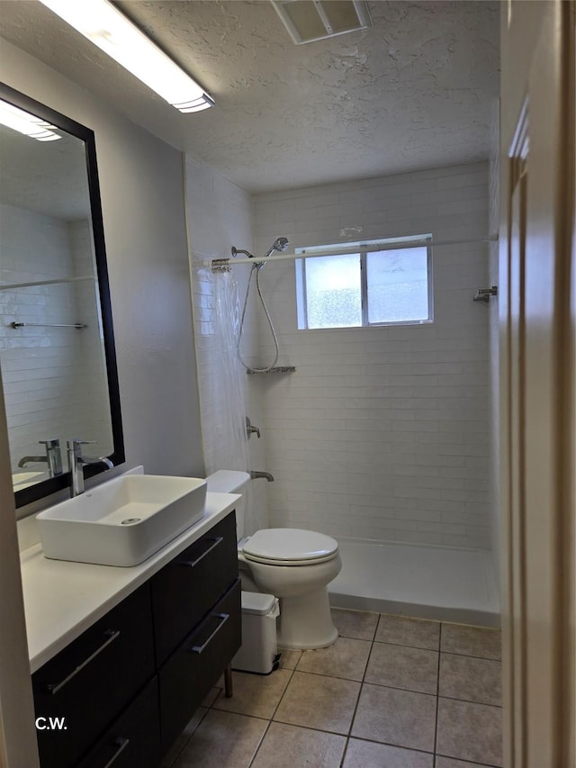 11834 Mulholland Dr, Meadows Place, TX 77477 - full bath with toilet, vanity, tile patterned floors, a tile shower, and a textured ceiling