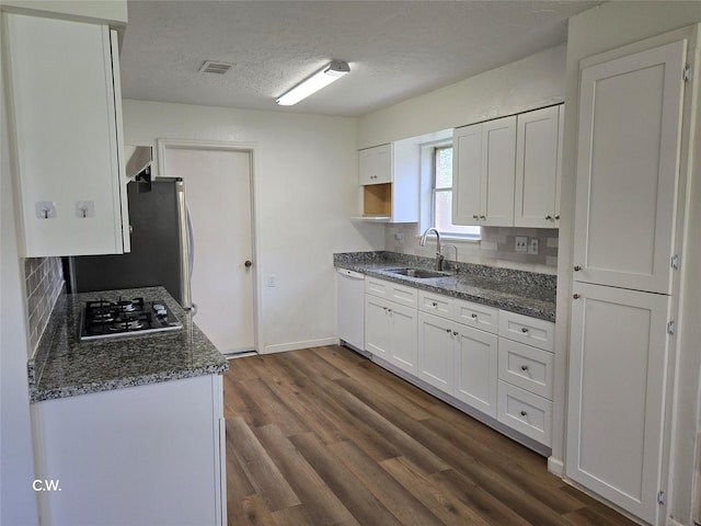 11834 Mulholland Dr, Meadows Place, TX 77477 - kitchen with a sink, appliances with stainless steel finishes, backsplash, white cabinets, and a textured ceiling