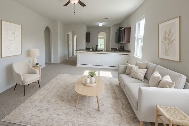 2507 Ocean Cove Cir, Rosenberg, TX 77469 - living area with arched walkways, a ceiling fan, light carpet, and baseboards