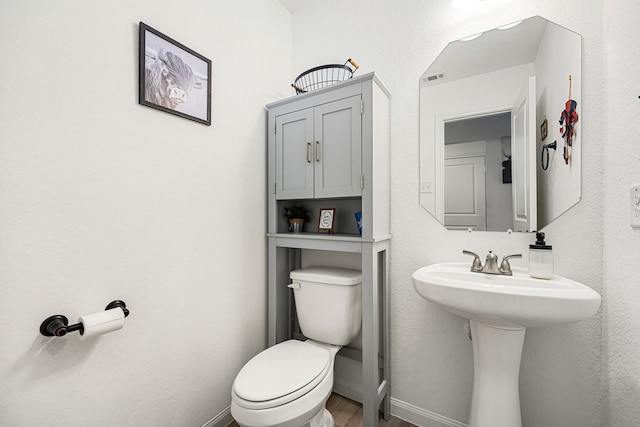 1250 22nd St, Hempstead, TX 77445 - bathroom featuring toilet, wood finished floors, and baseboards