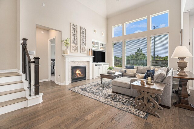 5711 Greenwood Colony Ct, Houston, TX 77059 - living area with wood finished floors, a towering ceiling, stairway, a fireplace, and baseboards