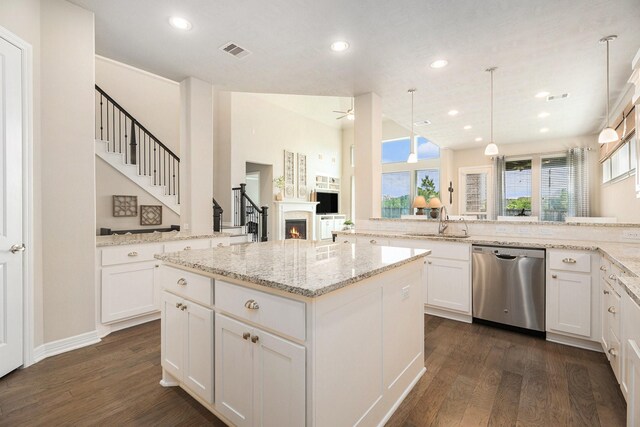 5711 Greenwood Colony Ct, Houston, TX 77059 - kitchen featuring stainless steel dishwasher, dark wood-type flooring, recessed lighting, a lit fireplace, and light stone countertops