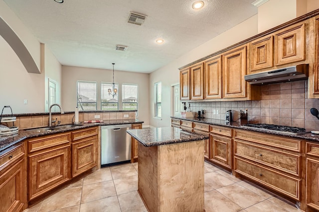 1102 Nautical Ln, Richmond, TX 77469 - kitchen featuring stainless steel appliances, under cabinet range hood, a sink, brown cabinetry, and a textured ceiling