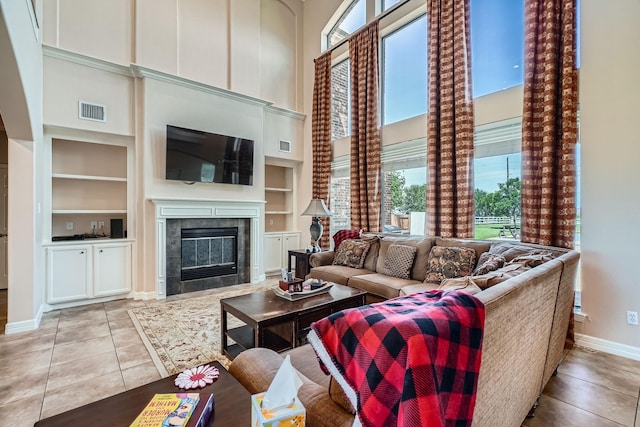 1102 Nautical Ln, Richmond, TX 77469 - living area featuring healthy amount of natural light, a high ceiling, built in features, baseboards, and tile patterned floors