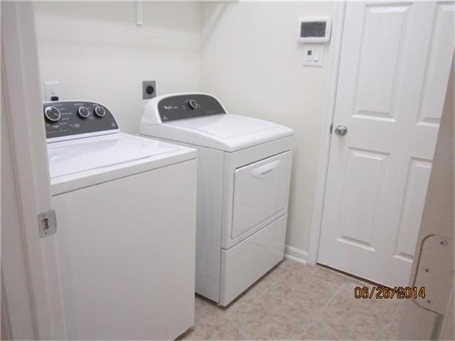 11030 Jacob Crossing Dr, Richmond, TX 77406 - laundry area with washing machine and clothes dryer and light tile patterned floors