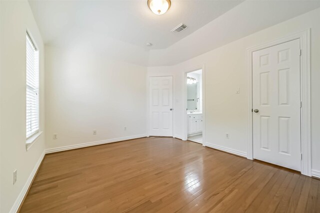 13331 Brentonwood Ln, Houston, TX 77077 - unfurnished bedroom featuring wood finished floors, baseboards, and connected bathroom