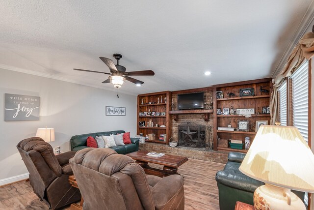 3623 Shore Shadows Dr, Crosby, TX 77532 - living area featuring wood finished floors, a ceiling fan, a fireplace, crown molding, and baseboards