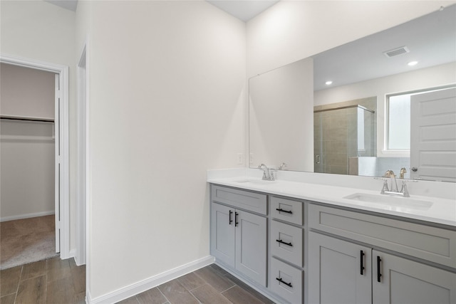 21531 Cypress Trellis Dr, Cypress, TX 77433 - bathroom with a shower stall, double vanity, a walk in closet, wood finished floors, and baseboards
