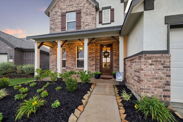 17218 Roxburgh Lake Ln, Hockley, TX 77447 - view of exterior entry featuring brick siding, stucco siding, and a porch