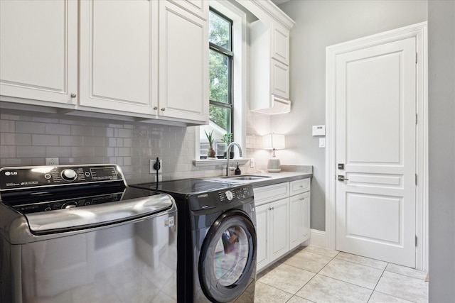 5202 Carew St, Houston, TX 77096 - washroom with washer and clothes dryer, cabinet space, light tile patterned flooring, and baseboards