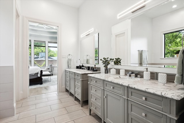 5202 Carew St, Houston, TX 77096 - bathroom with two vanities, ensuite bath, recessed lighting, and wood tiled floors