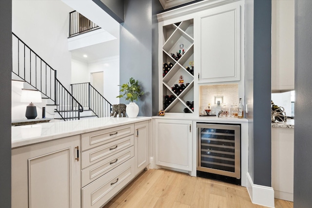 5202 Carew St, Houston, TX 77096 - indoor dry bar featuring beverage cooler, light wood-style floors, and stairs
