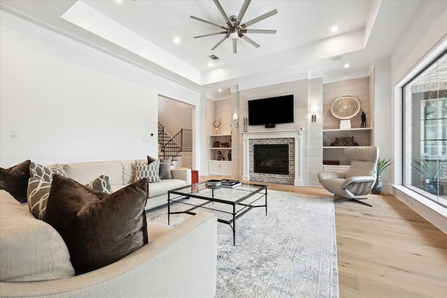 5202 Carew St, Houston, TX 77096 - living room with a raised ceiling, wood finished floors, stairs, ceiling fan, and a glass covered fireplace