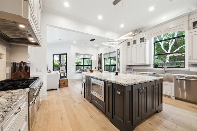 5202 Carew St, Houston, TX 77096 - kitchen with stainless steel appliances, range hood, white cabinetry, and recessed lighting