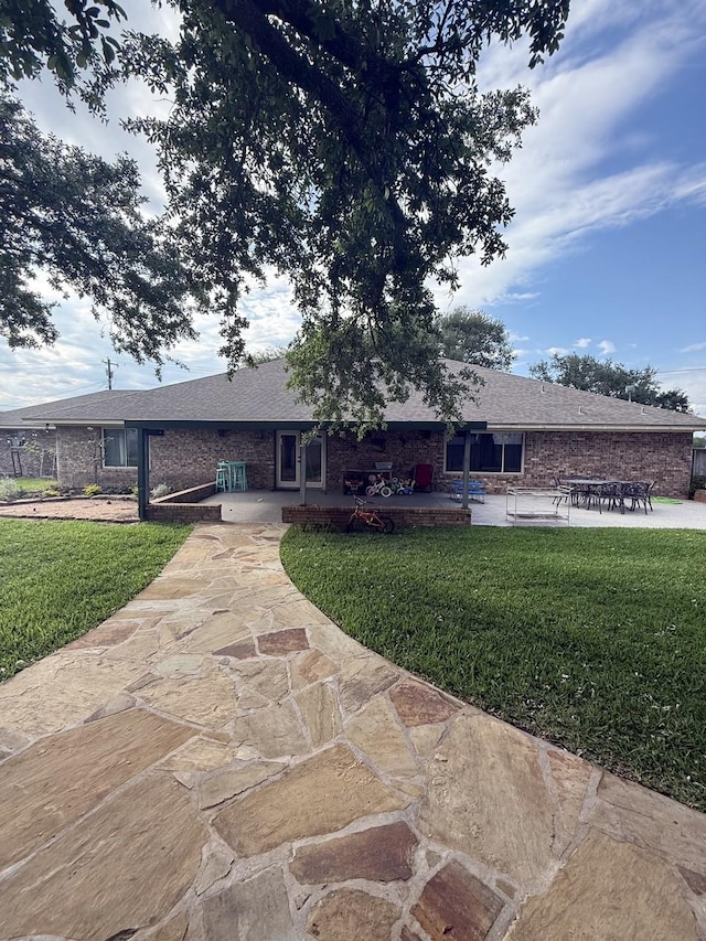 563 12th St, Bay City, TX 77414 - ranch-style house with a front lawn, a patio area, and brick siding