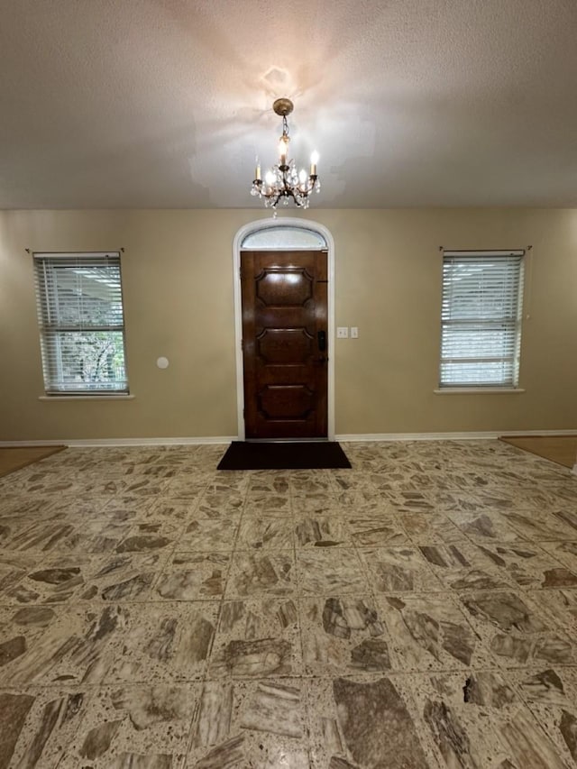 563 12th St, Bay City, TX 77414 - foyer with a chandelier, plenty of natural light, a textured ceiling, and baseboards